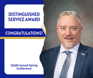Image of a man in a suit, he is smiling. Wording: Distinguished Service Award Kevin C. Garinger LEADS Annual Spring Conference