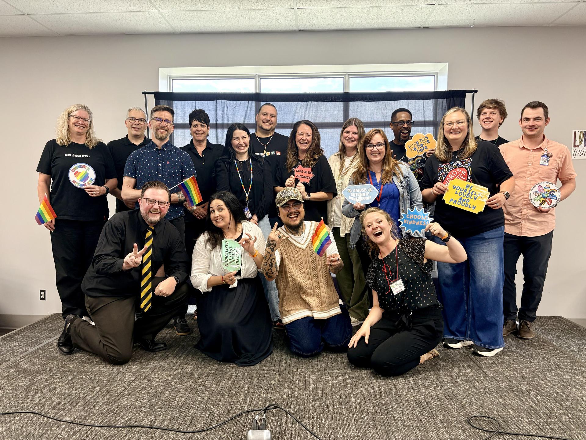 Staff reps posing with a variety of equity-related signs and symbols