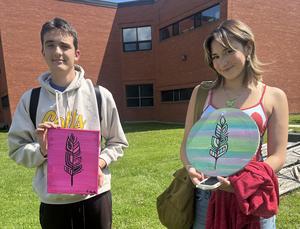 two students show art work