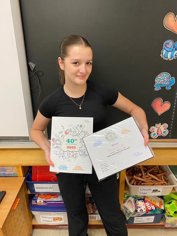 Young Author Award recipient holds up published poem.