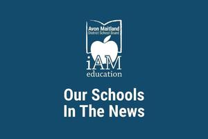 A dark blur poster with the Avon Maitland District School Board logo (an apple inside an open book) and the words “iAM education” above the headline “Our Schools In The News.”