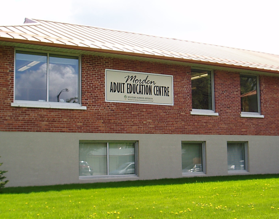 Brick building exterior with windows and a sign for Adult Education Centre.