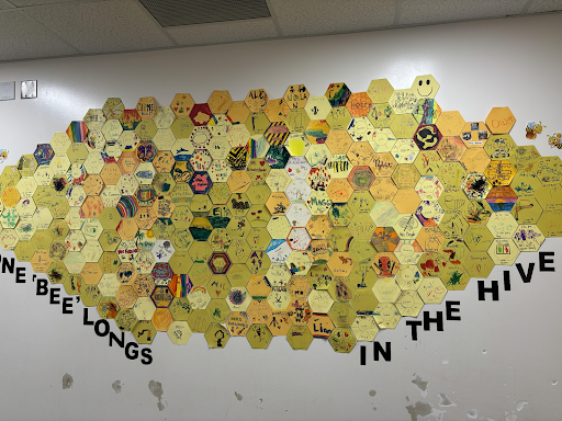 A group of yellow pieces of a hive that highlights student art work