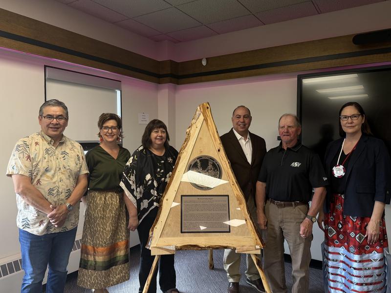 Dignitaries stand around treaty medallion
