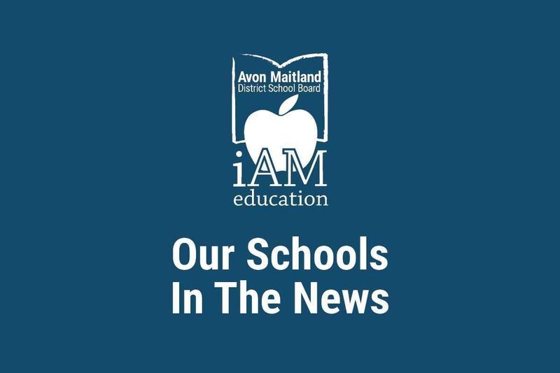 A dark blur poster with the Avon Maitland District School Board logo (an apple inside an open book) and the words “iAM education” above the headline “Our Schools In The News.”