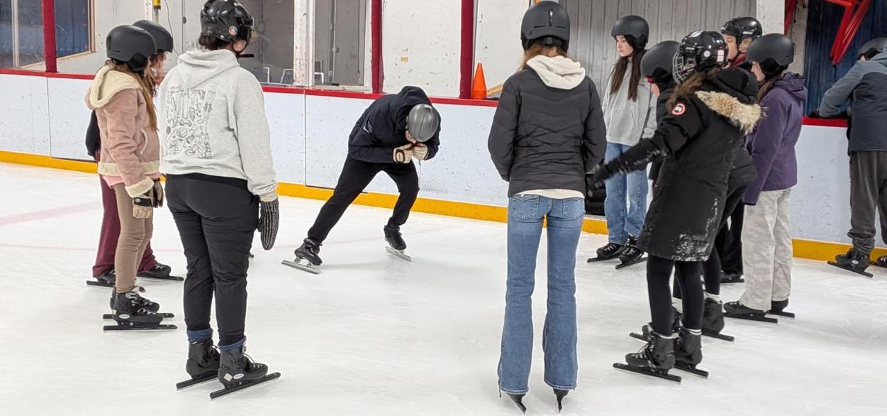 Students watching a demonstration of speed skating posture