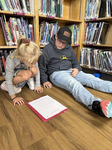 Older student helping a younger student with reading
