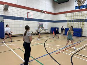 A team of Triple Ball students receives the ball.  One student is setting the ball.
