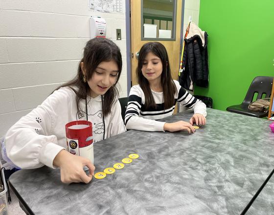 Two students sitting at a table doing an EAL activity