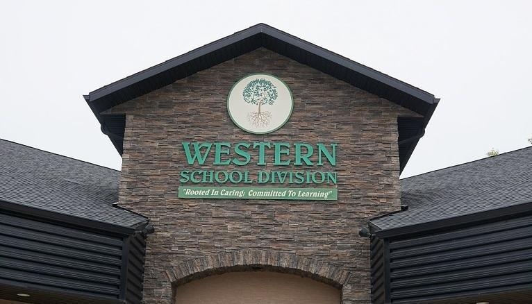 Front of the Western School Division Office showing brown brick building with Green Logo stating Western School Division