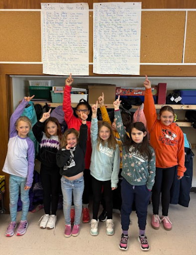 Students standing with their hands raised