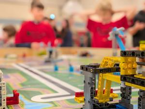 Lego in the foreground and two students watching in the background