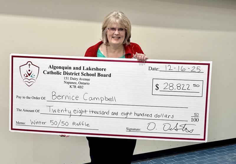 Bernice Campbell holding large cheque.