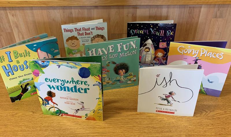 6 story books placed standing up on a table to show titles.