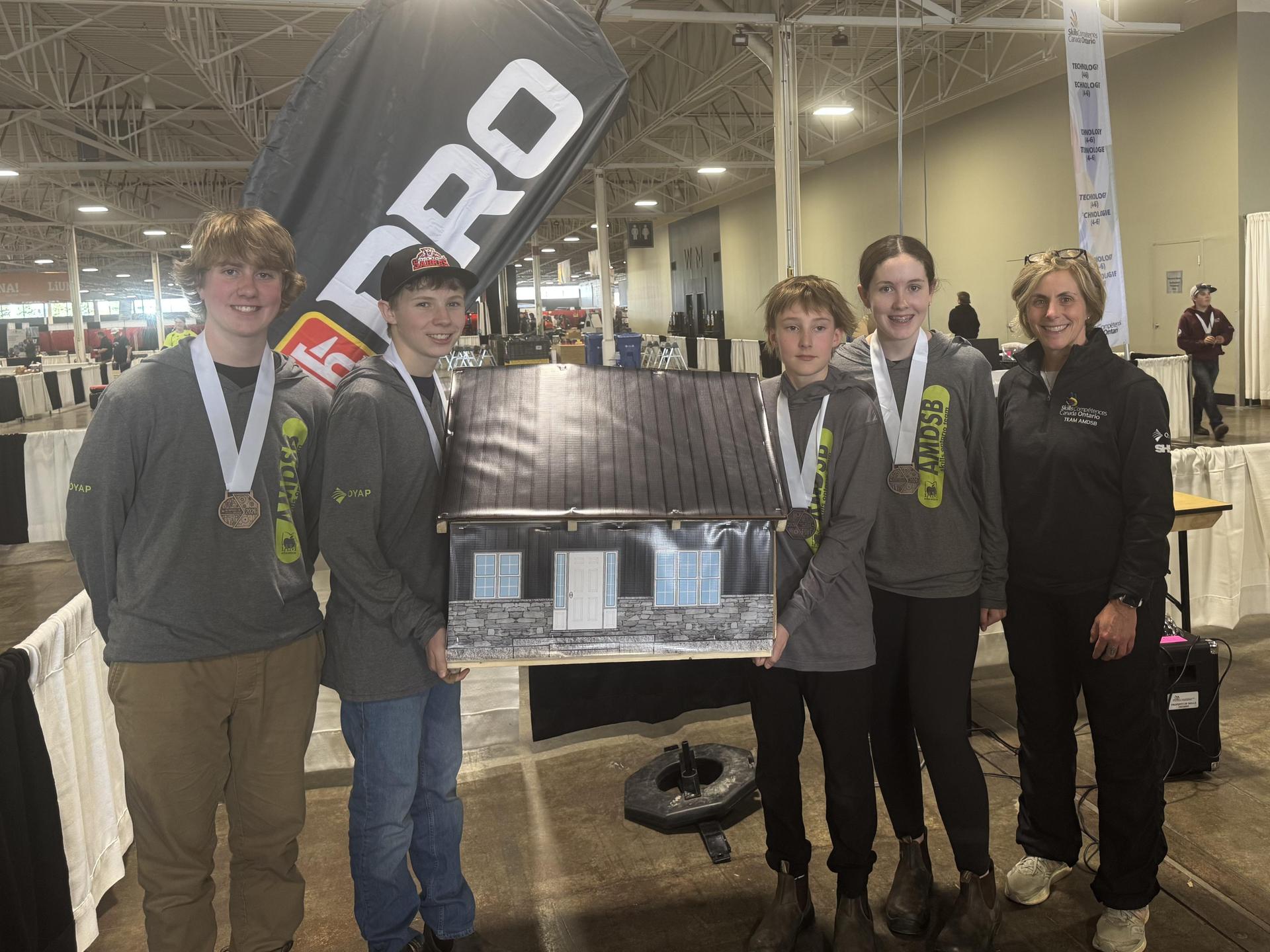 SHDHS construction team posing with their creation and wearing their bronze medals