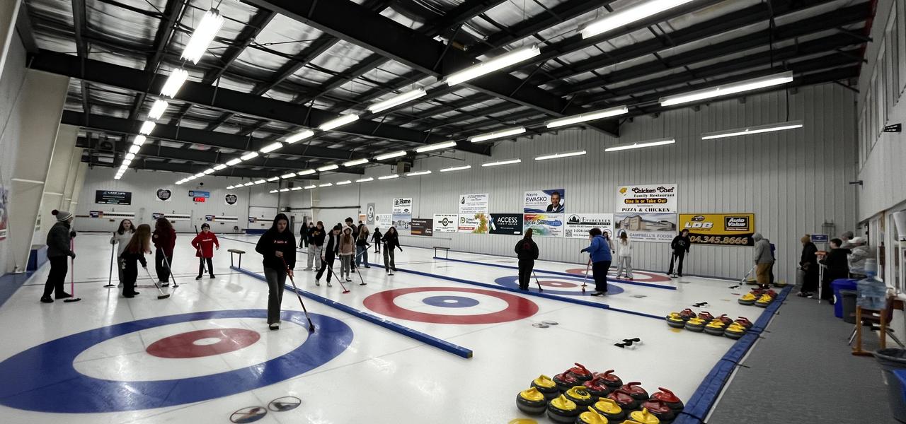 Students on the ice at a curling rink