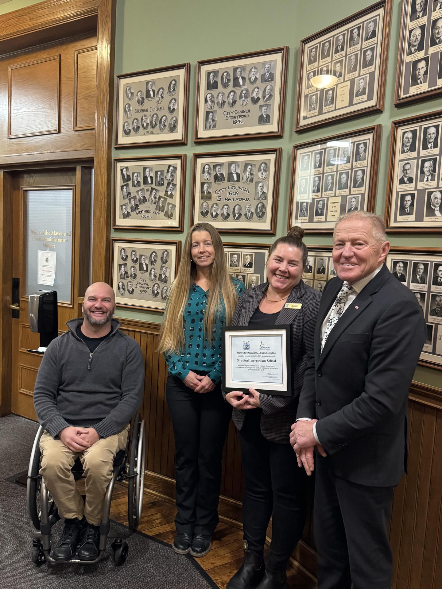 Cheri Carter holds an accessibility award while posing with principal Erin Cassone, Roger Koert and Stratford Mayor Martin Ritsma
