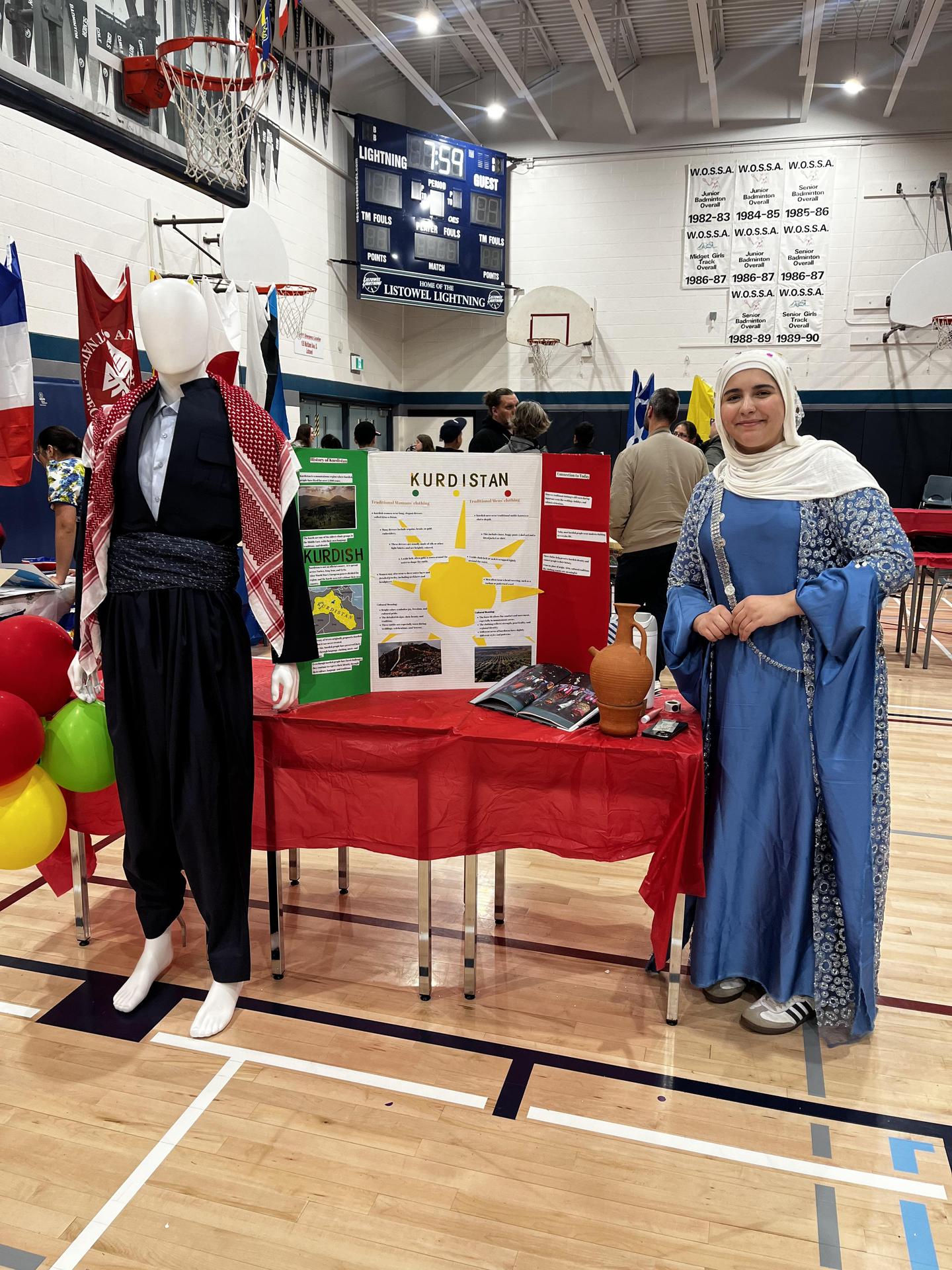 Student standing at a booth showcasing her culture