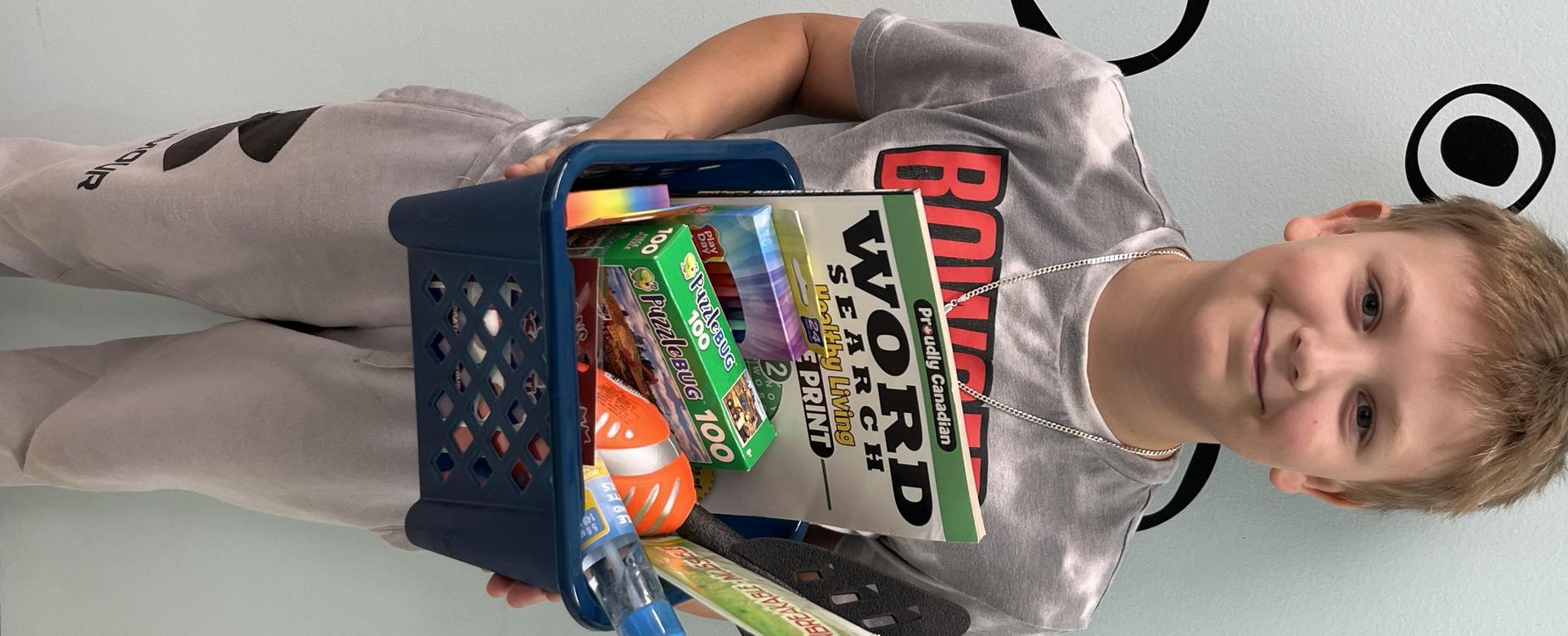 male student showing off prize basket