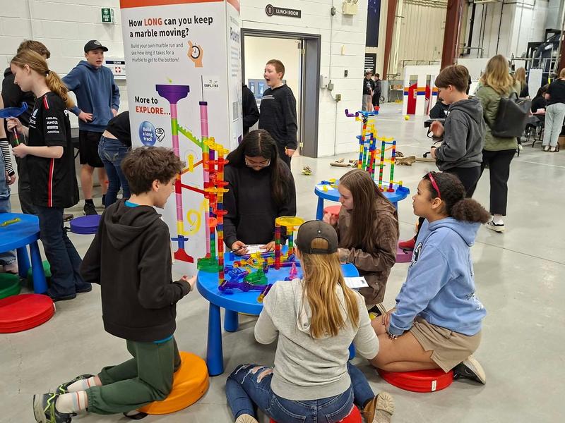 Students sitting around a Skills Expo table