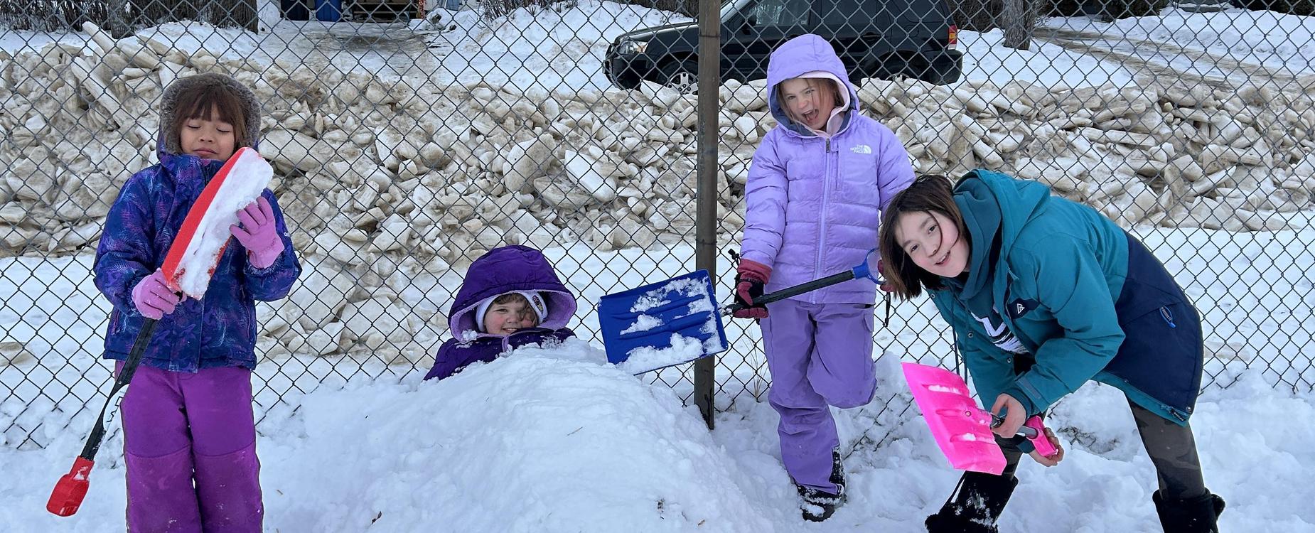 Students outside with shovels during recess.