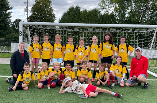 group of students posing in front of a soccer net