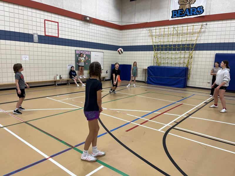 A team of Triple Ball students receives the ball.  One student is bumping the ball.