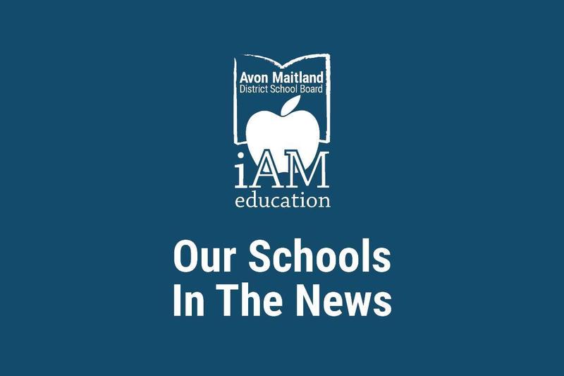 Blue graphic featuring the Avon Maitland District School Board iAM education logo with an apple inside an open book, and the text ‘Our Schools In The News.’