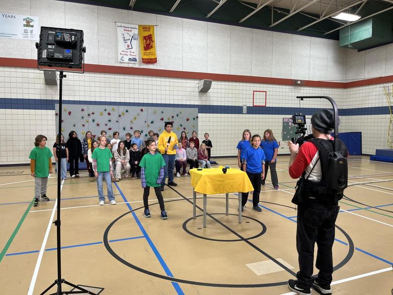 Grade 5 students in the gym gathered for a game show