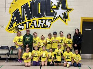 Handball students pose in front of an Anola Stars logo.
