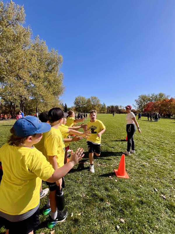 Students high fiving racers as they finish.