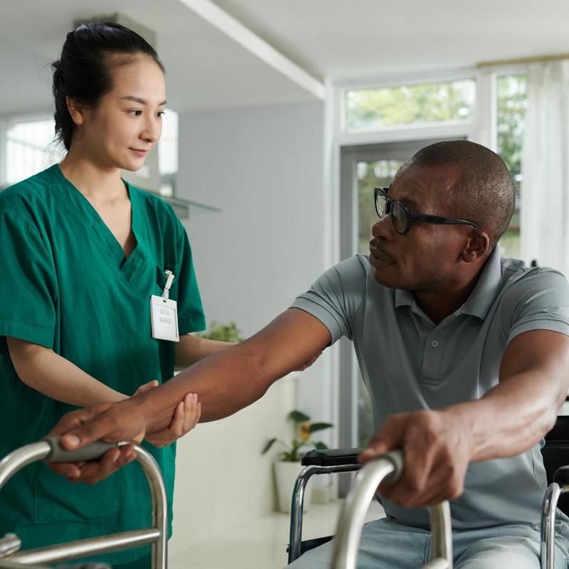 personal support worker with an individual with a walker who needs support.