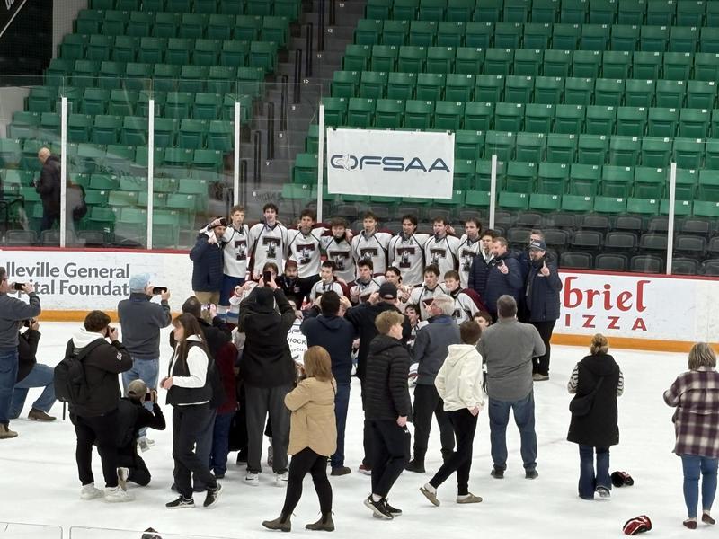 A group of secondary students on the ice, celebrating after the win of a hockey game.
