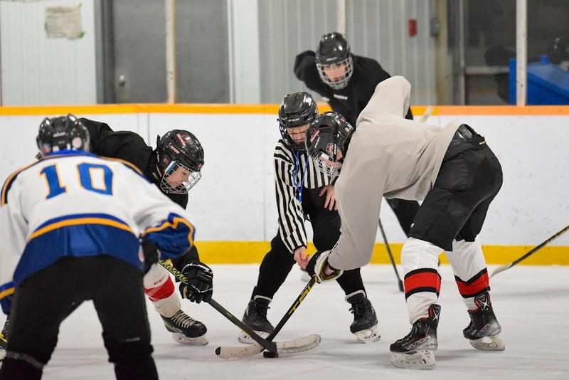 student and staff facing off at hockey game