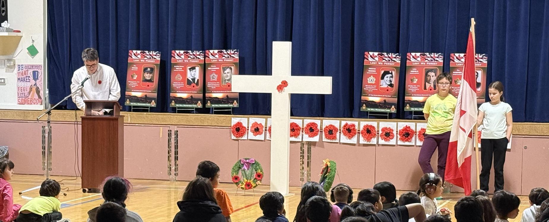 2 students standing honour guard for Remembrance Day service.