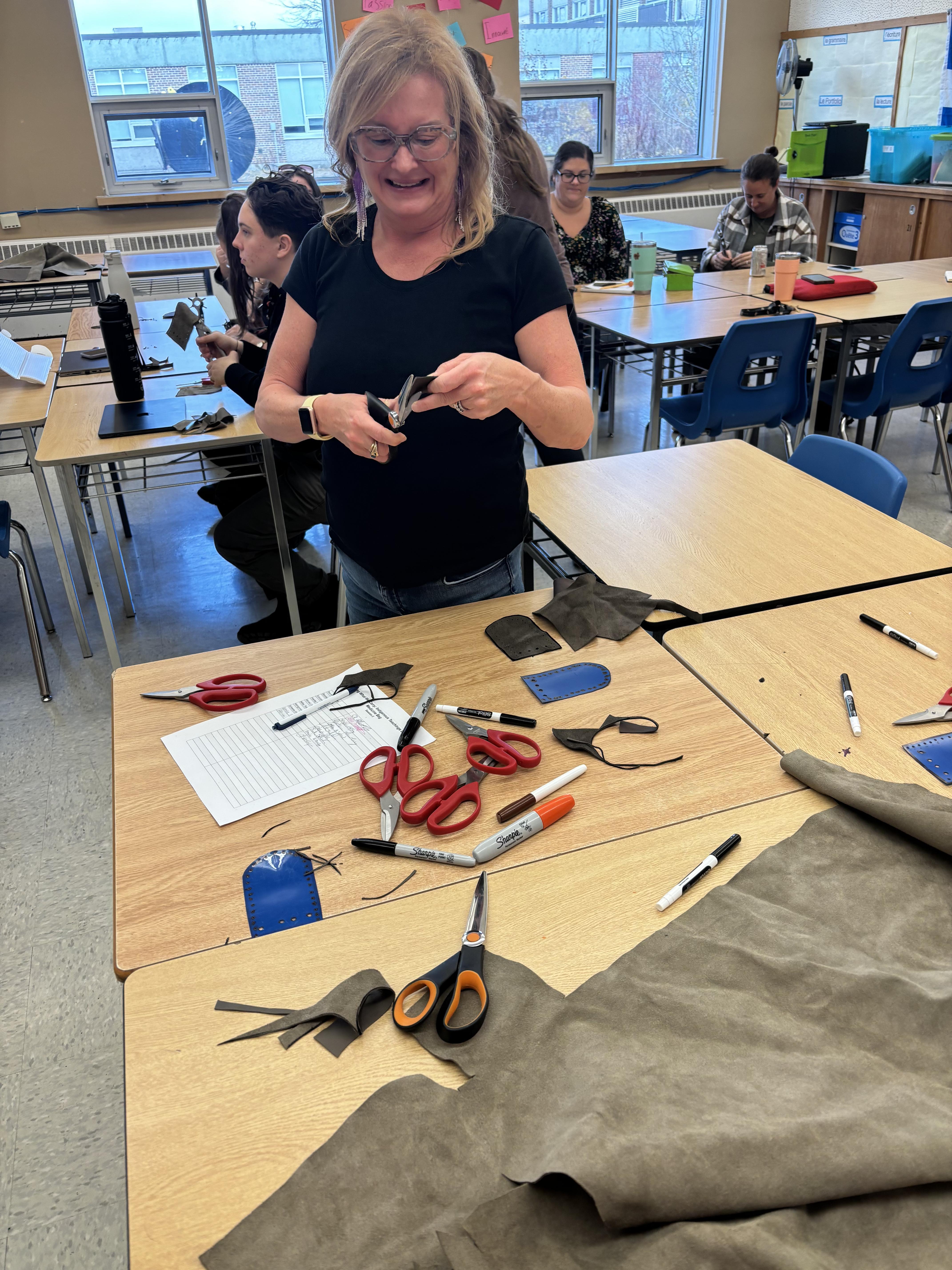 woman standing over a table cutting cloth