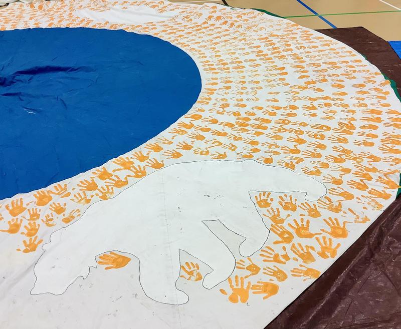A collection of painted orange handprints on the side of the tipi