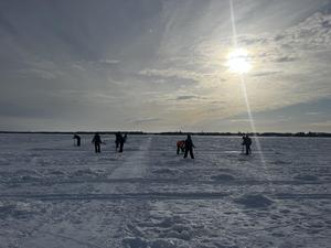 volunteers getting ice fishing holes ready for fishing