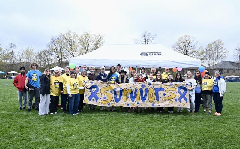 Survivors stand with students and staff at Relay for Life event.