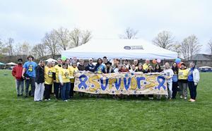 Survivors stand with students and staff at Relay for Life event.