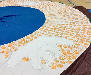 A collection of painted orange handprints on the side of the tipi